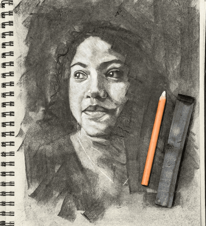 Portrait de femme au fusain et crayon, fond sombre et chevelure texturée dans un carnet a spirale.